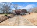 Picture of the backyard of a home with stone accents, featuring an expansive driveway at 1141 Milstead Ne Ave, Conyers, GA 30012