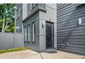 Stylish home entrance with a black framed door, gray siding, and a well manicured lawn at 244 Locust Ne St # B, Atlanta, GA 30317