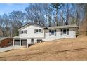 Two-story home showcasing a light painted-brick facade and a two-car garage with a long driveway at 3001 W Potomac Dr, Atlanta, GA 30344