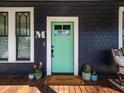 Charming front door with a 'Welcome' mat, plants, and the letter M at 1216 Mortimer Se Pl, Atlanta, GA 30317