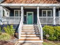 Inviting front porch with white railings, planters, a swing, and a bright teal door at 1216 Mortimer Se Pl, Atlanta, GA 30317