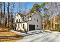 Side view of the white, two-story home and attached two-car garage at 1977 Westwood Se Cir, Smyrna, GA 30080