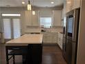 Modern kitchen with stainless steel appliances, white cabinetry, a center island, and a tile backsplash at 1200 Bar Harbor Pl, Lawrenceville, GA 30044