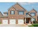 Charming brick-front home featuring a three-car garage, black shutters and trim, and a welcoming entrance at 1263 Polk Xing, Mcdonough, GA 30252