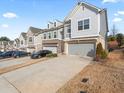 Modern townhome exterior featuring a spacious driveway and beautiful architectural details at 130 Maple Creek Way, Woodstock, GA 30188