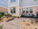 Cozy outdoor patio featuring stone pavers, lush landscaping, and comfortable seating at 130 Maple Creek Way, Woodstock, GA 30188