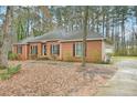 Traditional brick ranch home with a well-maintained lawn and a long driveway leading to a side-entry garage at 105 Spring Forest Way, Sharpsburg, GA 30277