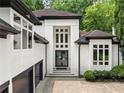 A modern home's front entrance featuring a striking white facade, large windows, and a well-manicured landscape at 4000 Wieuca Ne Rd, Atlanta, GA 30342