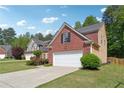 Traditional brick and siding home featuring an attached garage and manicured lawn at 3004 Westray Nw Ct, Marietta, GA 30064