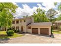 Classic two-story house featuring a two-car attached garage, red shutters, and a long driveway at 5678 Fern Creek Sw Dr, Lilburn, GA 30047