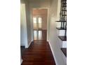 Elegant hallway featuring gleaming hardwood floors and decorative staircase at 5678 Fern Creek Sw Dr, Lilburn, GA 30047