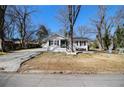 Quaint one-story home featuring a wide driveway, a cozy front porch, and mature trees in the front yard at 850 Third St, Stone Mountain, GA 30083