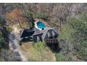 Expansive aerial view of a home with a covered pool nestled among lush, mature trees at 3320 Donegal Way, Snellville, GA 30039