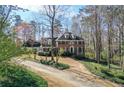 Elegant brick home with manicured landscaping, featuring a long driveway and surrounded by mature trees at 3320 Donegal Way, Snellville, GA 30039