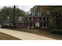 Traditional two-story brick home with black shutters, dormer windows, and a well-manicured front lawn and driveway at 3320 Donegal Way, Snellville, GA 30039
