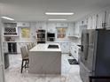 Bright kitchen features a large island, stainless steel appliances, and white cabinetry at 3320 Donegal Way, Snellville, GA 30039