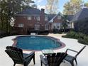 Enjoy a private backyard oasis featuring a sparkling pool, lounge chairs, and lush landscaping at 3320 Donegal Way, Snellville, GA 30039