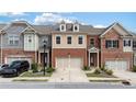 A row of beautiful townhomes showcases various exterior finishes and attached garages in a landscaped neighborhood at 2289 Emerald Sky Dr, Smyrna, GA 30080