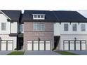 New townhome exterior with a two car garage and brick and white siding at 258 Depot Landing Rd # 53, Auburn, GA 30011