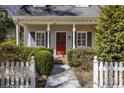 Charming home entrance with a red door, manicured hedges, and a classic white picket fence at 270 Grapevine Run, Sandy Springs, GA 30350