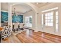 Bright dining room boasts hardwood floors, modern chandelier, and stylish blue accent wall, perfect for entertaining guests at 705 Chanson Sw Dr, Marietta, GA 30064