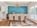 Dining room featuring a modern chandelier, stylish accent wall, and plenty of natural light at 705 Chanson Sw Dr, Marietta, GA 30064