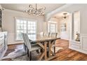 Elegant dining room with hardwood floors, white trim, statement chandelier, and archway offering an open and inviting space at 705 Chanson Sw Dr, Marietta, GA 30064