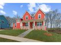 Attractive red two-story home featuring a quaint front porch and vibrant green lawn at 4039 Andover Cir, Mcdonough, GA 30252