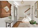 Bright foyer with hardwood floors, stairs, and a decorative mirror at 9625 River Lake Dr, Roswell, GA 30075