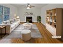 Bright, staged living room features a fireplace, large window, plush seating and a decorative striped rug at 1835 Big Haynes Ct, Grayson, GA 30017