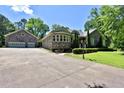 Spacious home with a large driveway, stone facade, and an additional detached two-car garage at 716 Counsel Ne Dr, Marietta, GA 30068