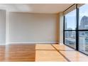 Cozy living room featuring hardwood floors and a large window with a view of the city skyline at 1280 W Peachtree St Nw # 3208, Atlanta, GA 30309