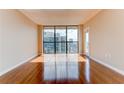 Sunlit, vacant living room with hardwood floors and large windows offering a glimpse of the cityscape at 1280 W Peachtree St Nw # 3208, Atlanta, GA 30309