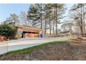 A two-car detached garage with an expansive driveway and mature trees at 123 Creek Cir, Stockbridge, GA 30281