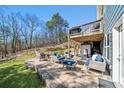 Outdoor living space with built in grill and a patio with comfortable seating and wooded view at 139 Stargaze Rdg, Canton, GA 30114