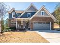 Charming two-story home featuring a brick and blue exterior, a well-manicured lawn, and a welcoming front porch at 139 Stargaze Rdg, Canton, GA 30114