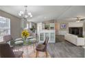 Open-concept dining area with a glass table and modern chandelier, blending seamlessly with the kitchen at 62 W Lakeview Dr, Temple, GA 30179