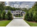 Gated entrance to an elegant home featuring manicured landscaping and mature trees at 700 N Island Dr, Atlanta, GA 30327