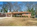 Traditional brick house featuring a covered carport and mature trees in the yard at 2631 Miriam Ln, Decatur, GA 30032