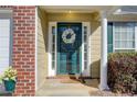 Inviting front door with green paint, a decorative wreath, sidelights and brick accent exterior at 4119 Ravenwood Ct, Union City, GA 30291