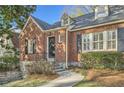 Close up of a red brick house with black shutters, dormer windows and mature landscaping at 2876 Alpine Ne Rd, Atlanta, GA 30305