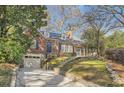 Lovely brick home featuring an attached garage and an inviting front yard with beautiful landscaping at 2876 Alpine Ne Rd, Atlanta, GA 30305