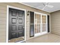 Inviting front porch featuring a stylish black front door, black shutters, and a ceiling fan at 6165 Picketts Nw Rdg, Acworth, GA 30101