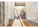 Grand foyer with hardwood floors, soaring ceilings, staircase with wood and iron railings, and natural light at 1641 Heathermoor Way, Dacula, GA 30019