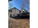 Backyard of a house featuring a chimney, door and windows to the outside, and a wooden deck at 2520 Deerfield Nw Dr, Kennesaw, GA 30144