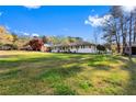 Wide shot of the property's exterior, featuring ample green space, mature trees, and a charming facade at 409 Shannon Way, Lawrenceville, GA 30044