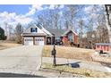 Charming brick home featuring a two-car garage, a well-maintained front lawn, and outdoor seating at 2720 Araglin Dr, Dacula, GA 30019