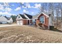 Charming brick home featuring a two-car garage, a well-maintained front lawn, and outdoor seating at 2720 Araglin Dr, Dacula, GA 30019