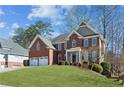 Beautiful brick home featuring a manicured lawn and attached two-car garage, perfect for suburban living at 4543 Fairecroft Ter, Suwanee, GA 30024