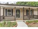 Inviting front porch with dark wood columns, a swing, and decorative details at the front door at 612 Rich Davis Rd, Hiram, GA 30141